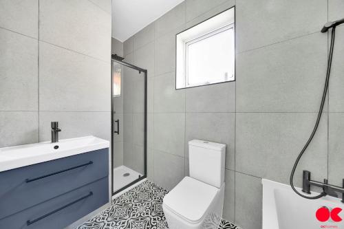 uma casa de banho com um WC, um lavatório e um chuveiro em Entire 2 bed flat London Zone 1-4 with private garden em Londres