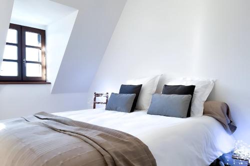 a white bed with two pillows on top of it at Gite Tout la-haut, 20 min du Puy Mary in Saint-Cirgues-de-Jordanne