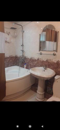 uma casa de banho com um lavatório, uma banheira e um WC. em Квартира em Samarkand