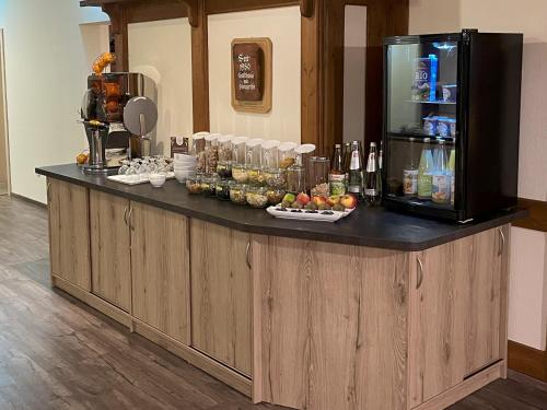 a bar in a hotel with a counter with drinks at Hotel am Steinertsee - Kassel-Ost in Kaufungen