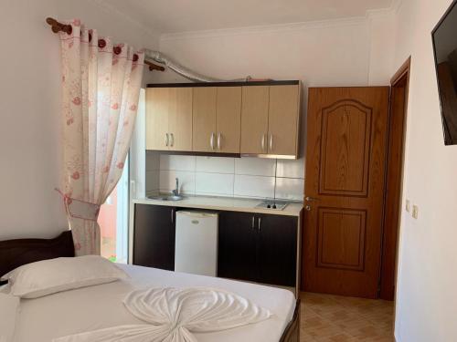 Un dormitorio con una cama y una pequeña cocina. en Vila Florand Sela, en Ksamil