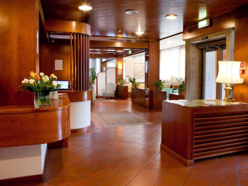 a lobby with a waiting room with flowers on the counter at Hotel Marconi in Padova