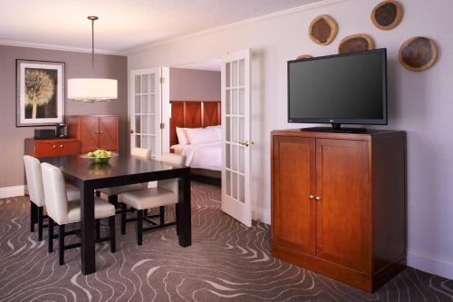 a hotel room with a dining table and a television at Detroit Metro Airport Marriott in Romulus
