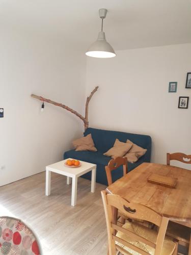 un salon avec un canapé bleu et une table dans l'établissement Gîte des Louisettes et Paulin 300m de la plage, à Soulac-sur-Mer