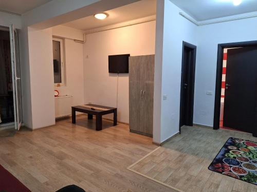 - un salon avec une table et une télévision dans l'établissement Cazare Regim Hotelier apartament 2 camere Militari, à Roşu
