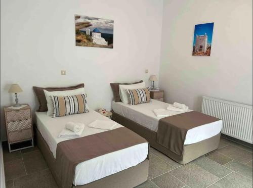 two beds in a small room with twoermottermott at Diavrouxas House in Sifnos in Cherronisos