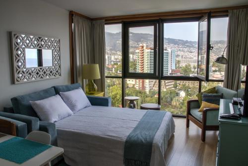 a bedroom with a bed and a large window at Monumental Apartment in Funchal