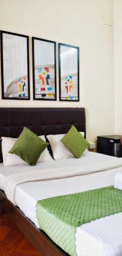 two beds in a room with four windows at Baga Beach Paradise in Baga