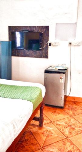 a room with a bed and a trash can in a room at Baga Beach Paradise in Baga