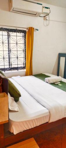 a large bed in a room with a window at Baga Beach Paradise in Baga