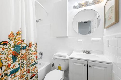 a bathroom with a toilet and a sink and a mirror at Lovely 2 BR condo in Sailboat Bend in Fort Lauderdale