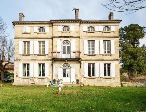 une vieille maison avec une cour herbeuse devant elle dans l'établissement Grande chambre avec SDB privée, à Bazas