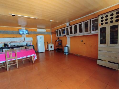a large room with a kitchen with a table and cabinets at Ñande renda in Ciudad del Este