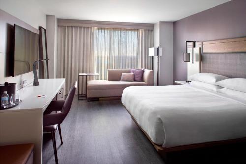 a hotel room with a large bed and a chair at Marriott Raleigh City Center in Raleigh