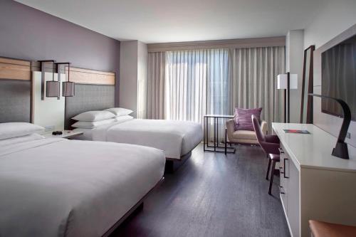 a hotel room with two beds and a desk at Raleigh Marriott City Center in Raleigh