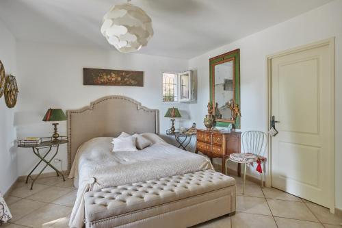 een slaapkamer met een bed, een tafel en een spiegel bij Maison de Golfeur in Mallemort