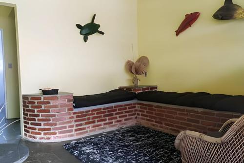 a living room with a brick fireplace and a couch at Chalés Caraguá Massaguaçu in Caraguatatuba