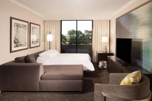 a hotel room with a bed and a couch and a tv at Omaha Marriott in Omaha