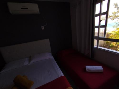 a small bedroom with a bed and a window at Village Hospedagens in Natal