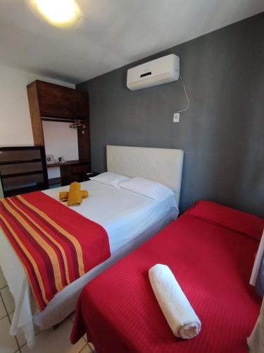 a hotel room with two beds and a air conditioner at Village Hospedagens in Natal