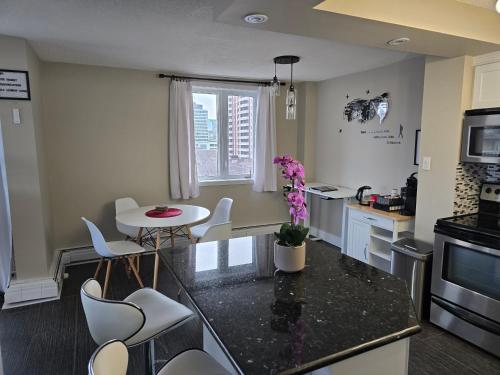 a kitchen with a counter and a table and chairs at Smart Stylish Downtown Condo- 2 bedrooms in Saskatoon