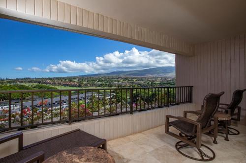 a balcony with chairs and a view of a city at Kaanapali Alii in Lahaina