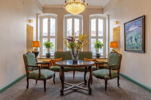 een woonkamer met een tafel en stoelen en een kroonluchter bij White Brig Guesthouse in Hudiksvall