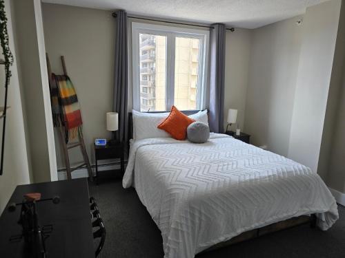 a bedroom with a large bed and a window at Smart Stylish Downtown Condo- 2 bedrooms in Saskatoon