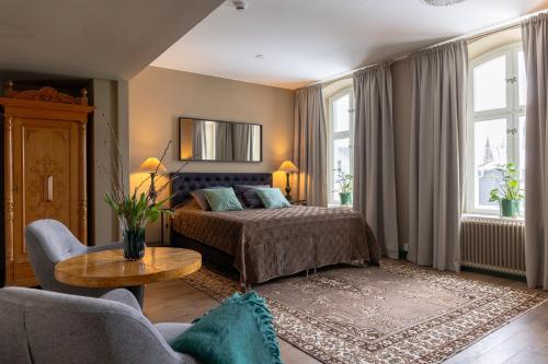 een slaapkamer met een bed, een bank en een tafel bij White Brig Guesthouse in Hudiksvall