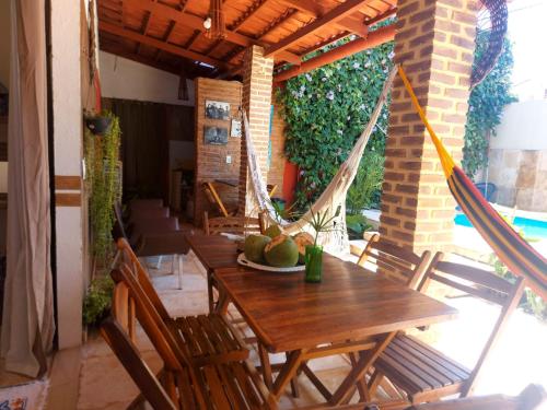 un patio con mesa, sillas y hamaca en Casa Boa Venttura Piscina,guajiru,flecheiras e mundaú en Trairi