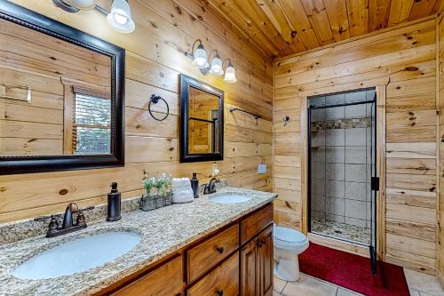 a log cabin bathroom with two sinks and a toilet at Cabin In The Sky in Epworth