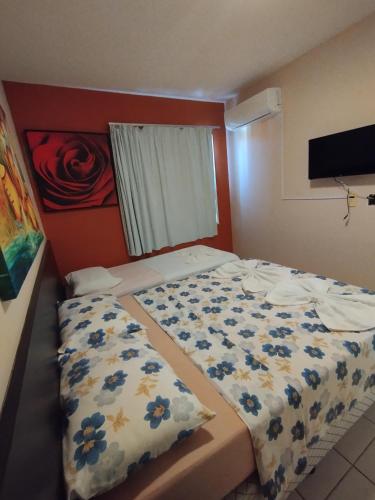 a small bedroom with a bed with blue flowers at Village Hospedagens in Natal