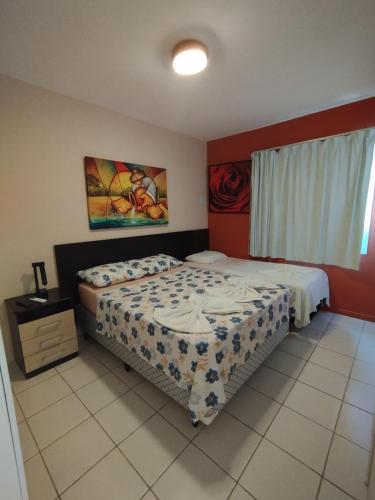 a bedroom with two beds and a painting on the wall at Village Hospedagens in Natal