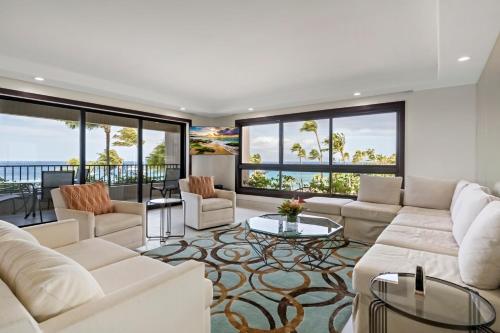 a living room with white furniture and large windows at Kaanapali Alii in Lahaina