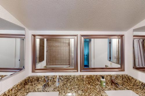 ein Badezimmer mit zwei Waschbecken und zwei Spiegeln in der Unterkunft Rock Manor in Flagstaff
