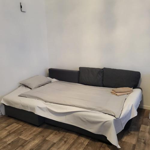 a bed in a room with a white wall at Gemütliche Appartement in Bad Oeynhausen