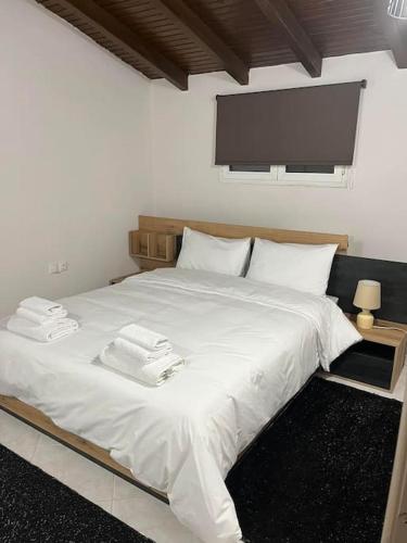 um quarto com uma cama branca e toalhas em The penthouse em Maniákoi