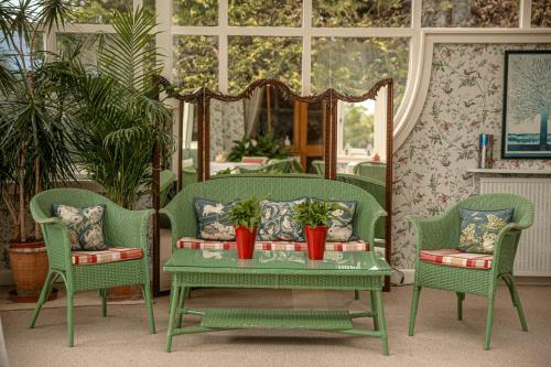a living room with two chairs and a table with plants at Kinloch House Hotel in Blairgowrie