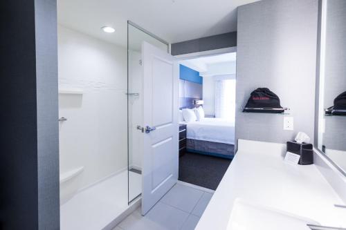 a bathroom with a walk in shower next to a bed at Residence Inn by Marriott Oklahoma City Northwest in Oklahoma City