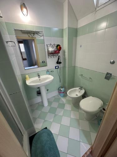 a bathroom with a sink and a toilet and a mirror at Isoladelmiele in Marettimo