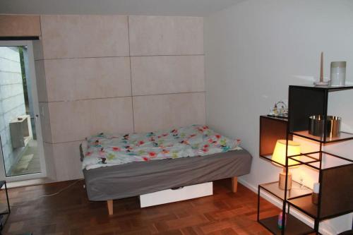 a small bed in a room with a small table at Anneks med eget toilet og bad - gratis parkering in Horsens