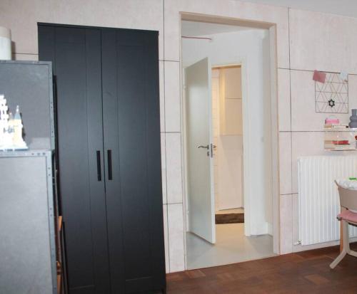 a black cabinet in a room with a refrigerator at Anneks med eget toilet og bad - gratis parkering in Horsens