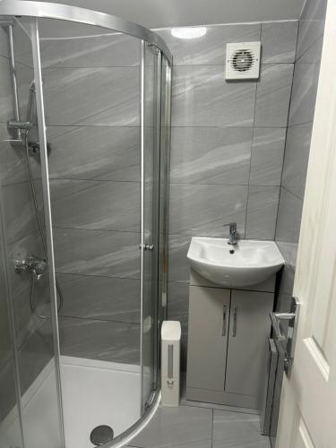 een badkamer met een douche en een wastafel bij London Holiday Home in Londen