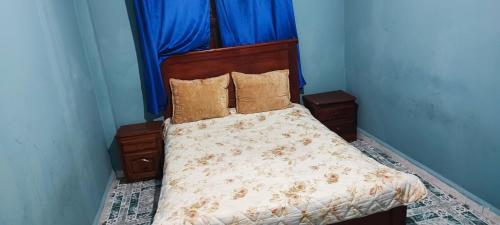 a bed in a bedroom with a blue wall at FATIMA.MARHABA in Azrou