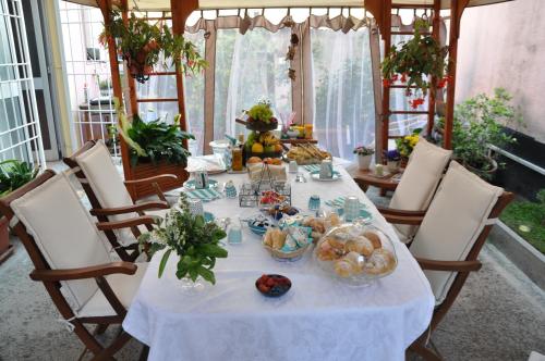 una mesa con un mantel blanco y algo de comida en ella en B&B Iulia Augusta, en Albenga