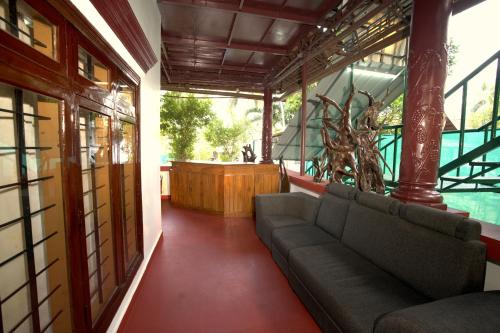 a living room with a couch in a building at Garggi Backwater Retreat in Kottayam