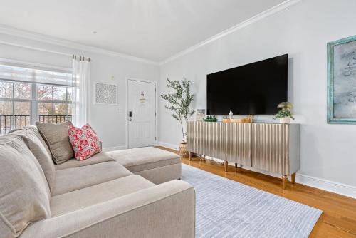 a living room with a couch and a flat screen tv at Walk to Arena and Downtown Auburn in Auburn