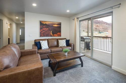 a living room with a couch and a table at 6E Family Friendly RedCliff Condo, POOL & HOT TUB in Moab