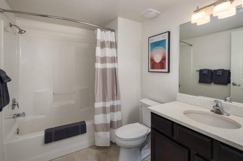 a bathroom with a toilet and a sink and a shower at 6E Family Friendly RedCliff Condo, POOL & HOT TUB in Moab