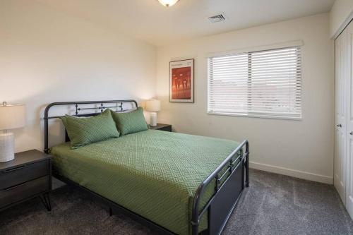 a bedroom with a green bed and a window at 6E Family Friendly RedCliff Condo, POOL & HOT TUB in Moab